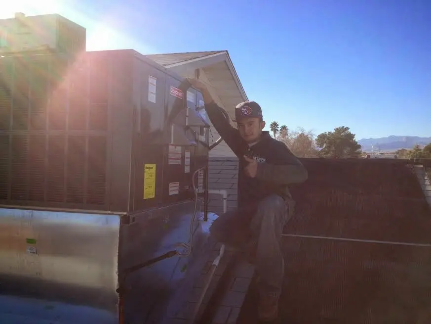 HVAC technician performing Boiler Repair on a rooftop unit in Verona